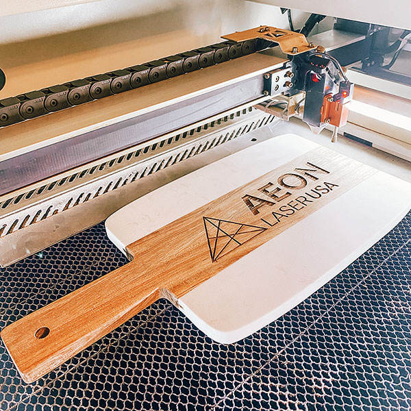 Custom wood and marble cutting board with Aeon Laser USA logo engraved on it