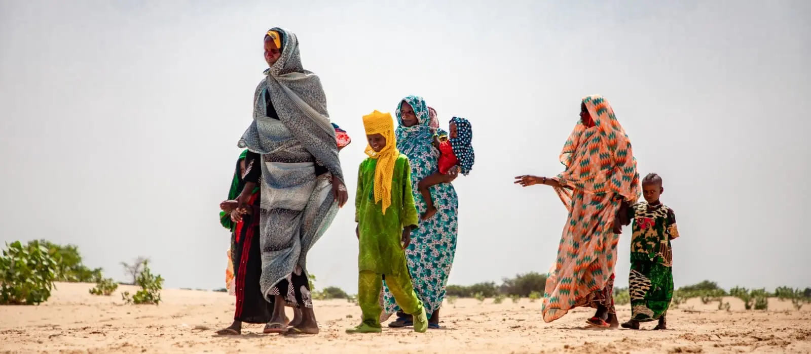 Women and children in the barren landscape of the Lake Chad region.
