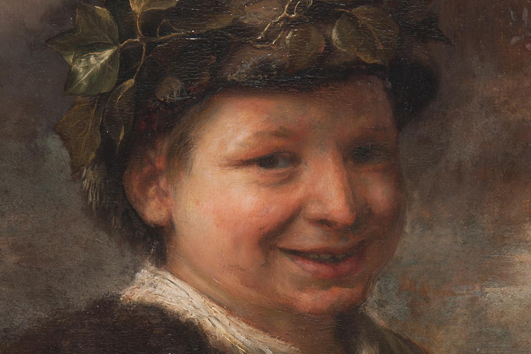 Detail portrait of young boy with olive leaves in hair