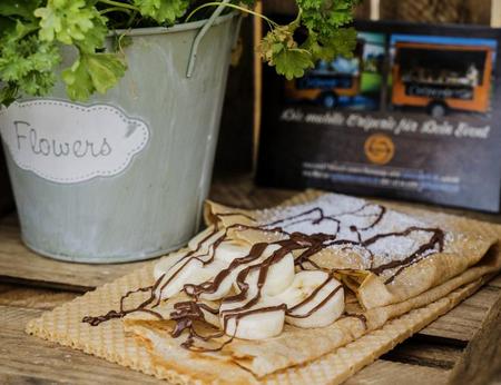 süßer Crepe, gefüllt mit Nutella-Banane, serviert auf nachhaltigem, essbarem Waffelteller