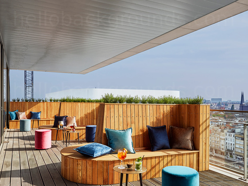 Outdoor bar deck with city views and array of colourful padded seating and wooden benches  Zoom background