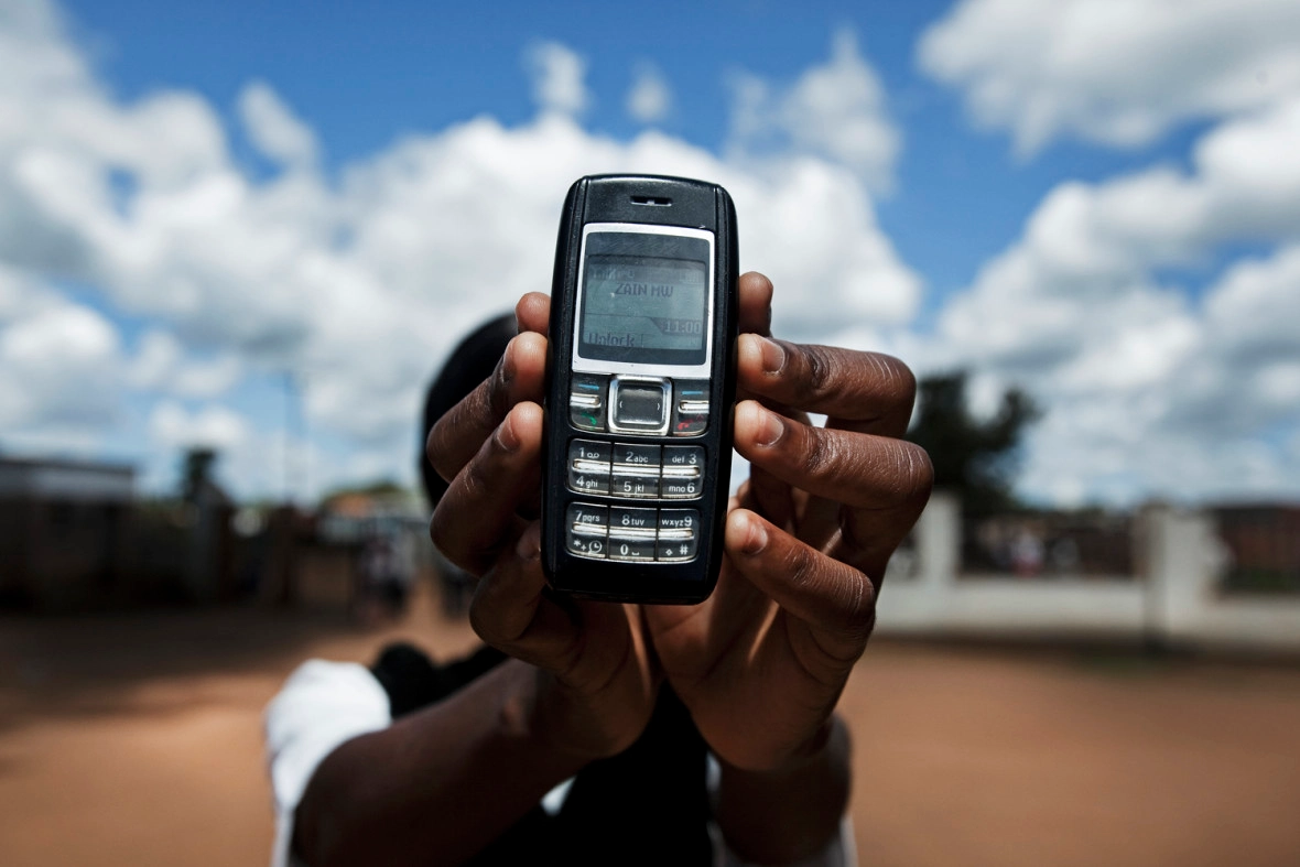Nurse Tiwonge Chisale from the Kabudula Community Hospital holds a mobile phone, Lilongwe District, Malawi.