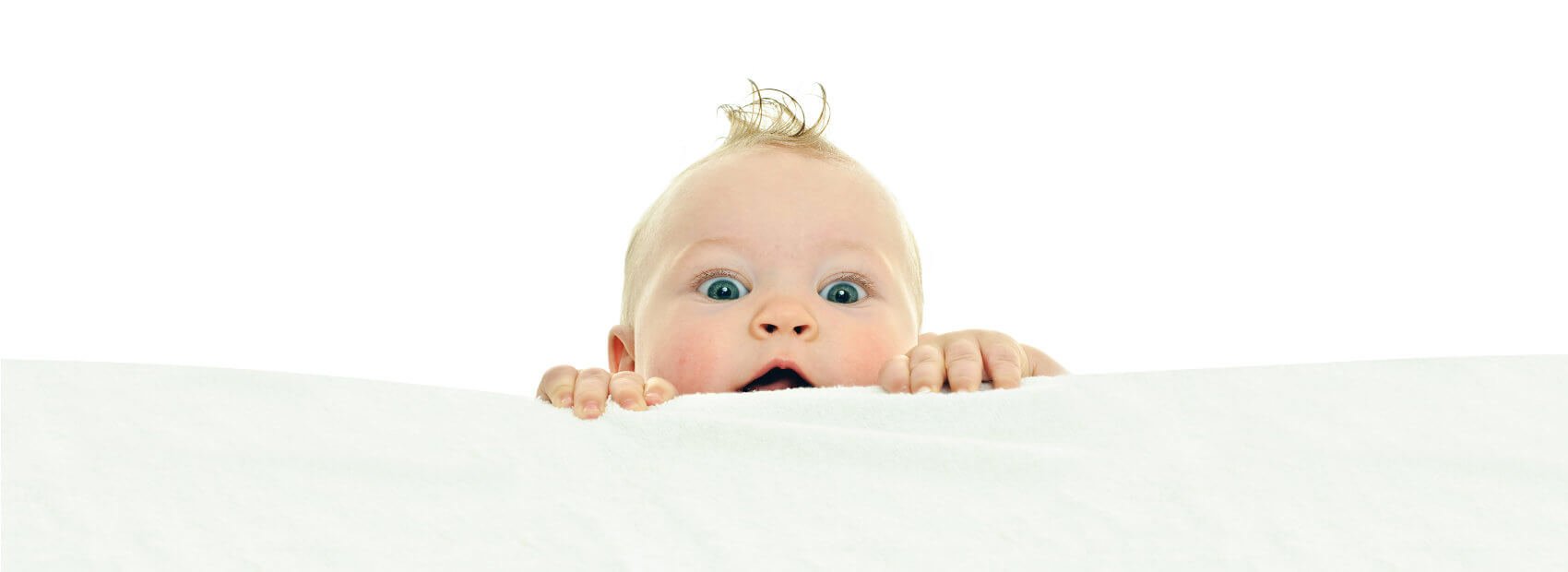 A baby pearing over the top of an object.