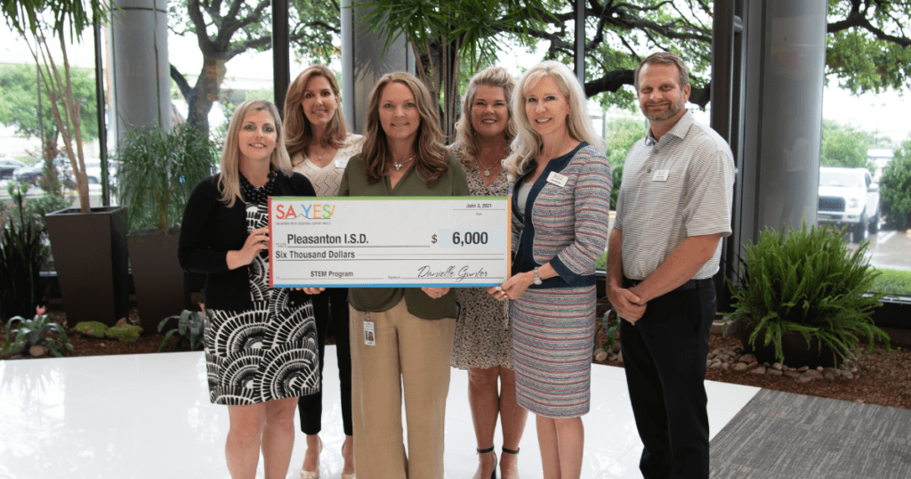An image of SA YES staff giving a large check to Pleasanton ISD staff for $6000 for STEM programs