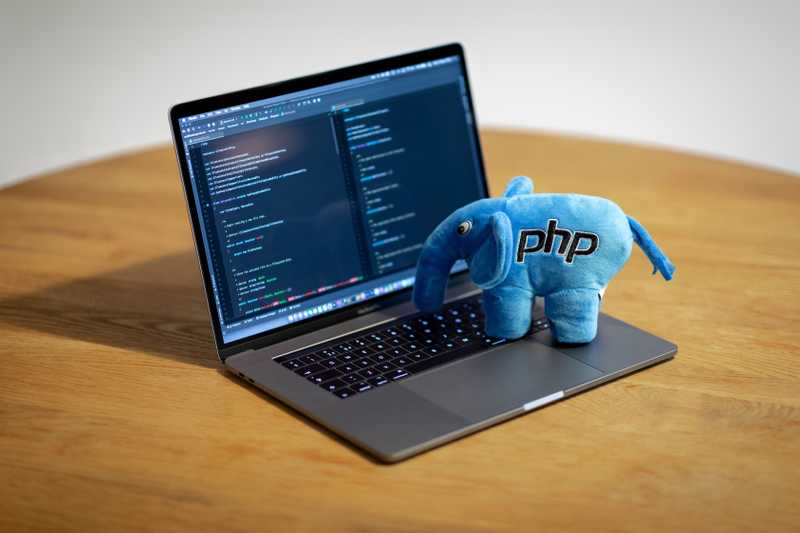 Photo of PHP plush elephant on a Macbook Pro, with PHP Storm running on it.