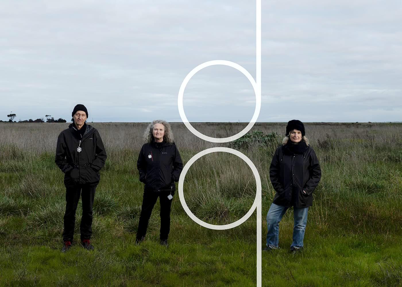 Madeleine Flynn, Tim Humphrey & Jenny Hector standing in a grassy field on a cloudy day looking at the camera