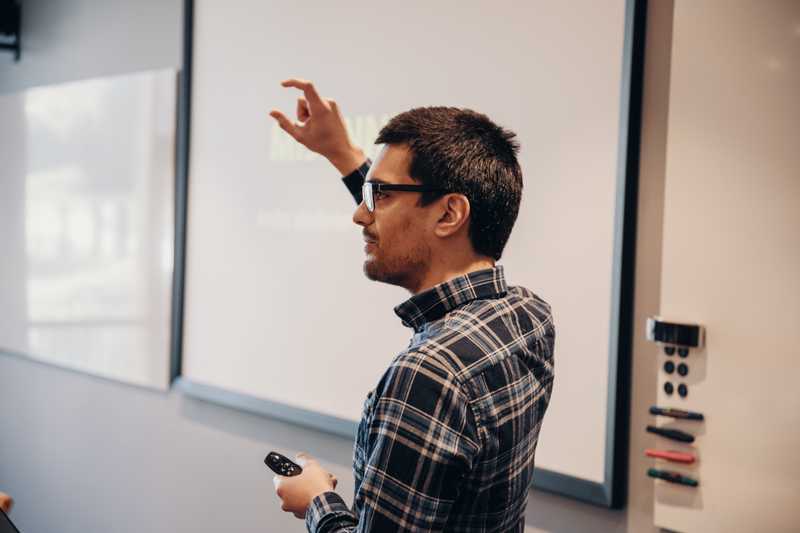 Dekorativt bilde. En mann som står foran en whiteboard og gestikulerer.