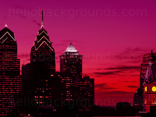 Urban cityscape at twilight featuring various tall buildings with some displaying lights from windows Skype background