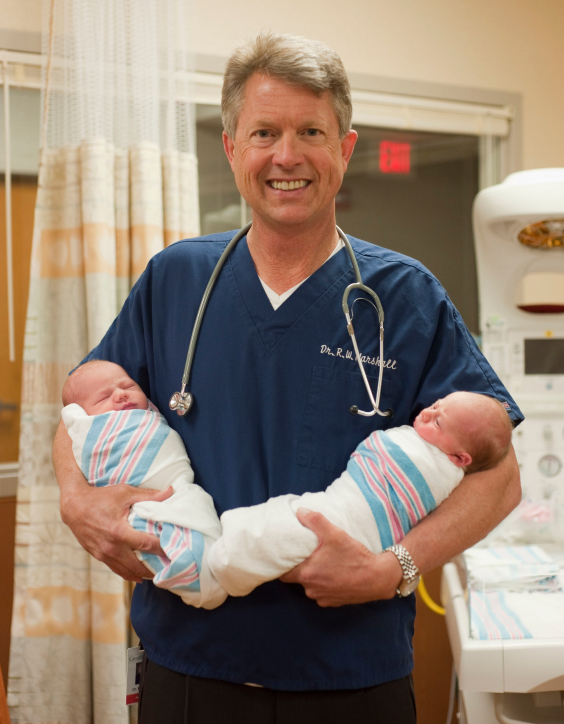 Dr. Marshall holding two babies