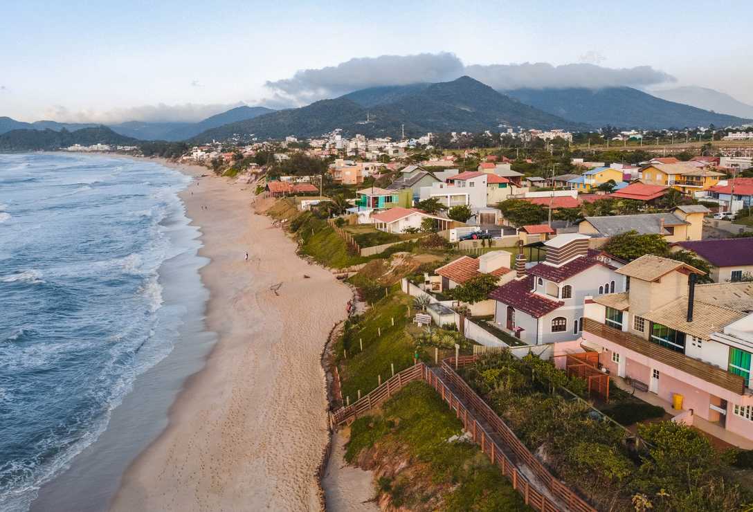 Vista aerea da faixa de terra da praia do campeche, pegando cassas e o mar