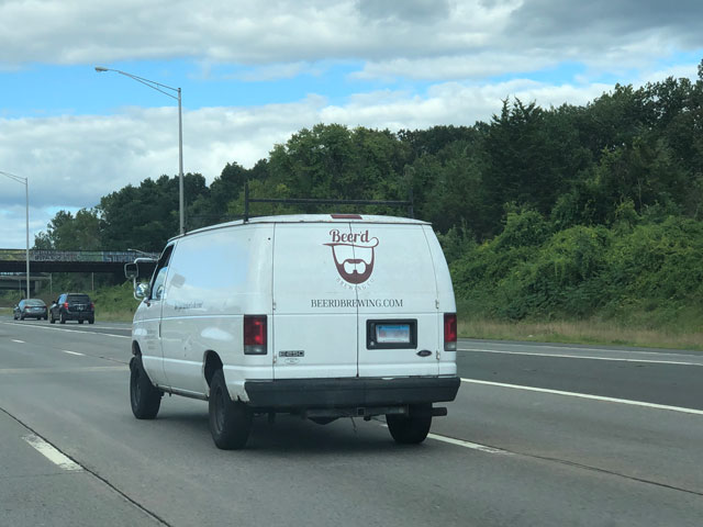 A Beer'd delivery van driving on I-84