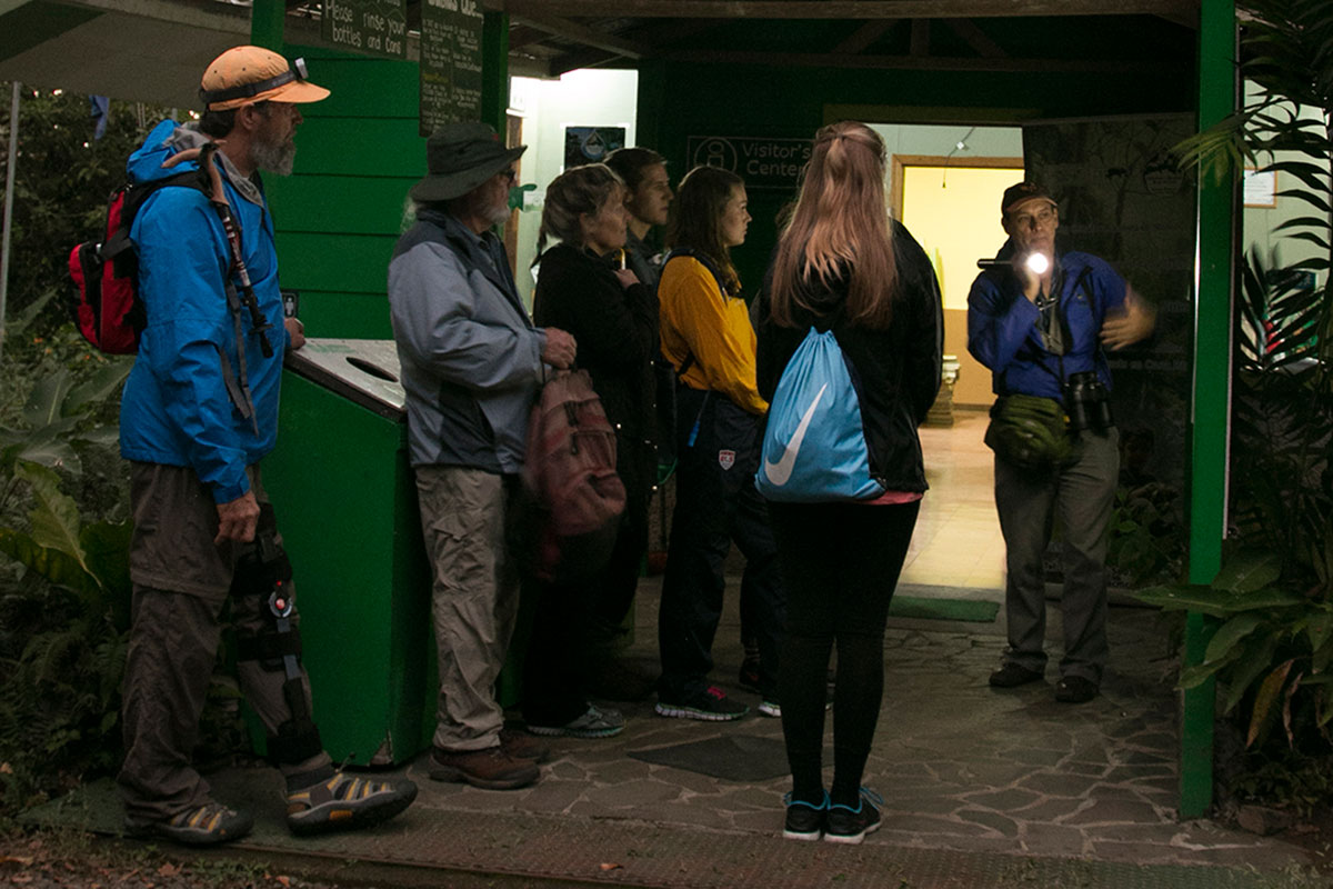A group of visitors stands at the visitor’s entrance of the Children’s Eternal Rainforest before a night tour