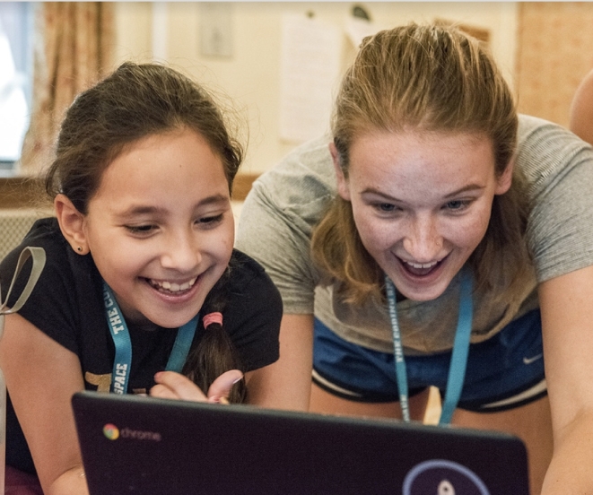 Two girl camp coders smiling at a computer