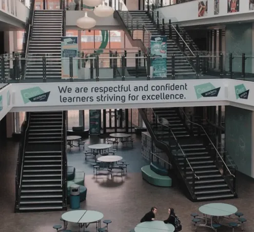 A image of Oasis Academy Oldham with their slogan, "We are respectful and confident learners striving for excellence."
