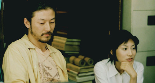 A screenshot from the film 'Cafe Lumiere' of a man, Hajime, and Yoko sitting together.