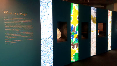 A gallery section titled: 'What is a Map?'. There are rows of lightboxes and showcases in the wall.
