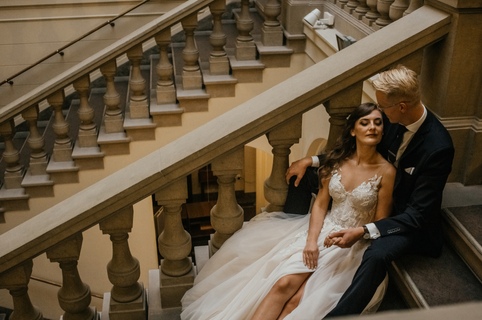 Zdjęcia ślubne Poznań - para trzymająca się za ręce na schodach