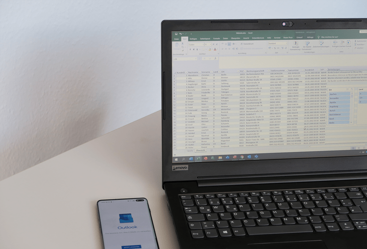Outlook-Excel Smartphone mit Outlook-App und Laptop mit Excel-Tabelle