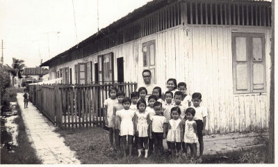 A group of children and a man pose outside a row house at Jalan Nanas.