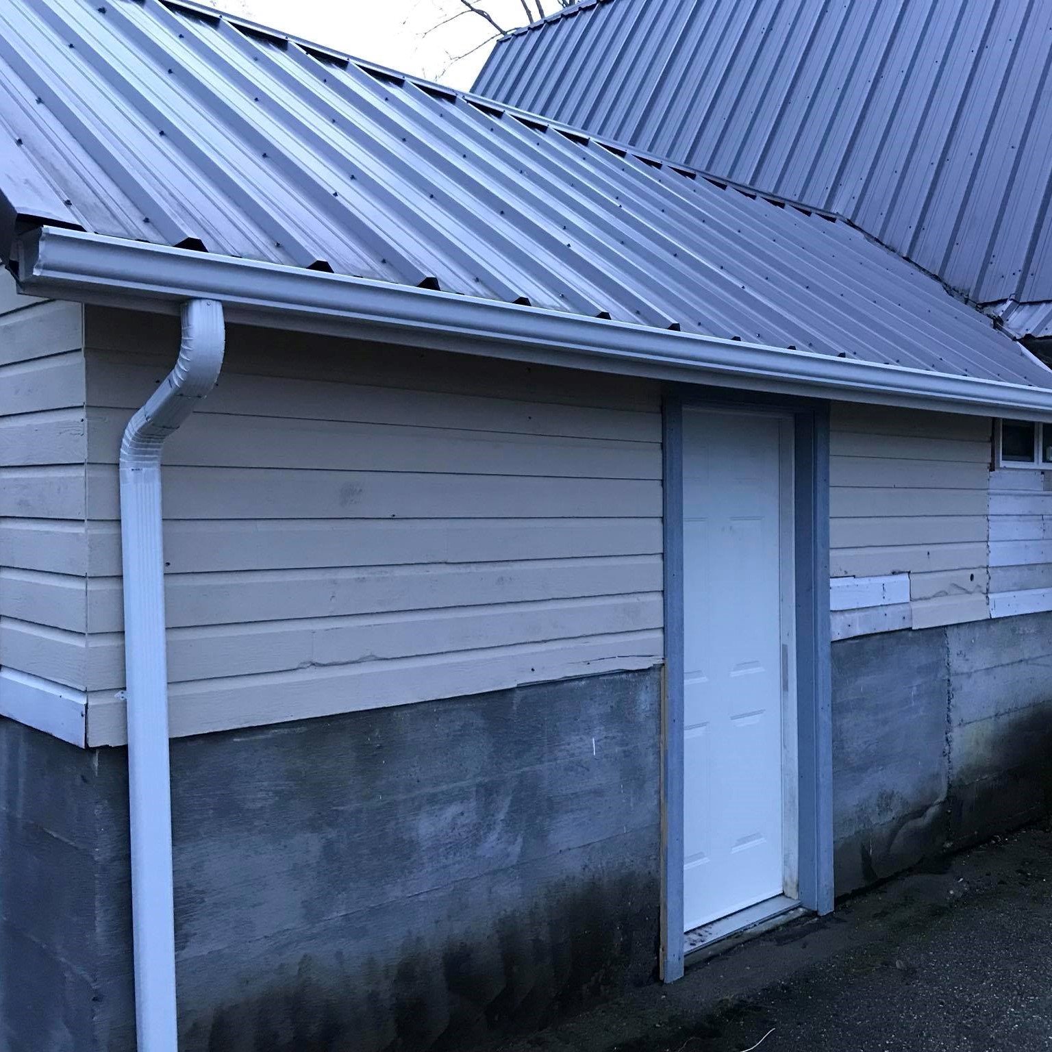 side angle new gutter installtion on a yellow and stone home