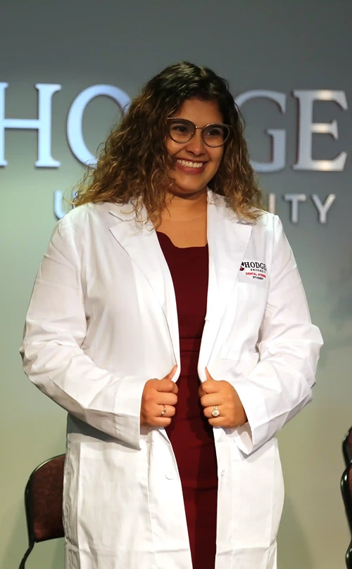 Hodges University Dental Hygiene Student putting on her White Coat for the firs time