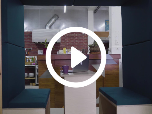 Private meeting booth with blue padded seating in modern office with exposed brick walls Microsoft Teams background