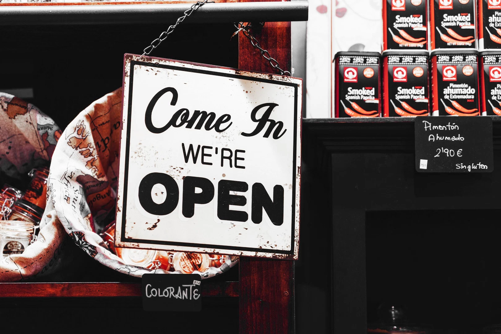 A sign outside a shop window that reads "Come in, We're open!"