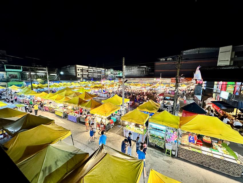 A sea of yellow tents of a night market seen from a high vantage point