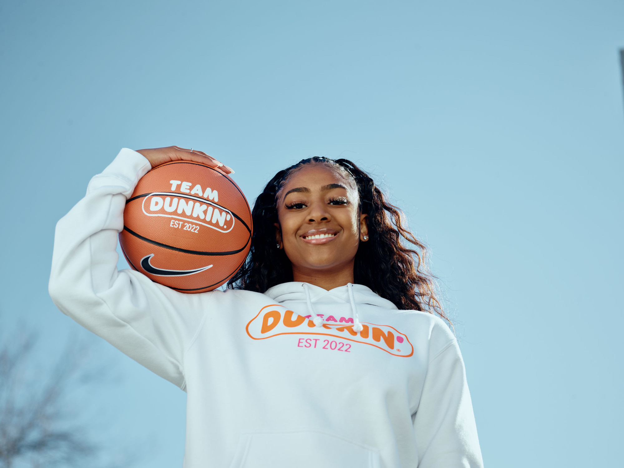 Deja Kelly posing with a Team Dunkin’ basketball