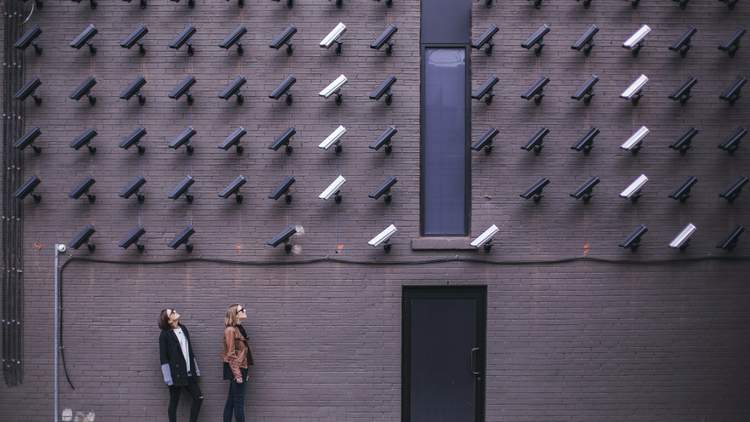 Image of security cameras pointed at two individuals