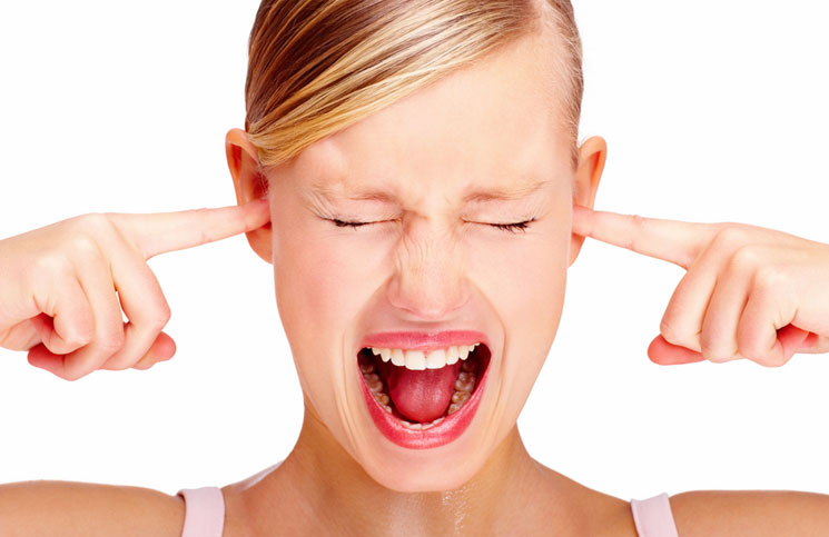 woman plugging ears and screaming
