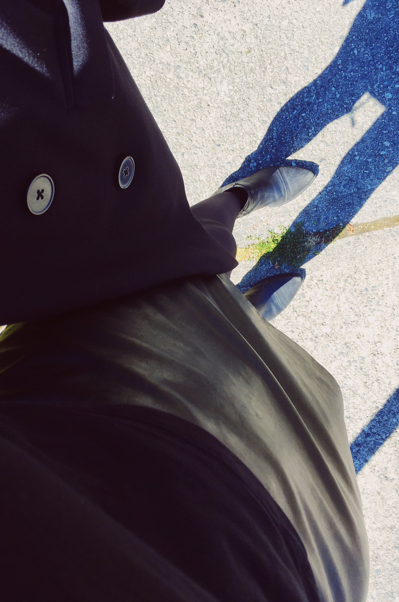 A top-down photo of my all-black outfit, taken outside in strong sunlight.