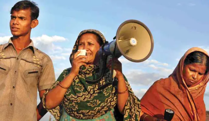 A community participating in Paribartan with a megaphone