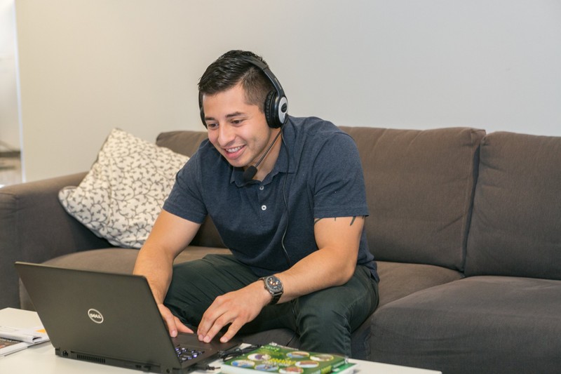 Guild Education employee working on a computer with a headset