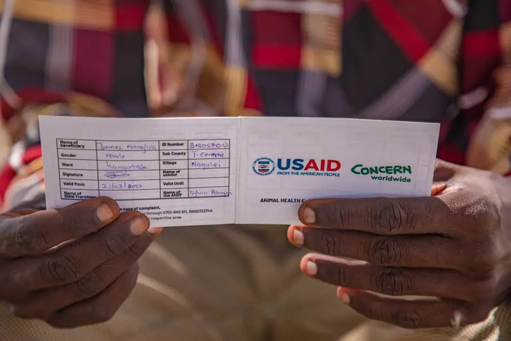 Kenyan man holds a voucher for livestock assistance provided by Concern Worldwide and funded by US foreign aid