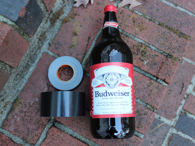 A 40oz bottle of Budweiser beer and two rolls of duct tape
