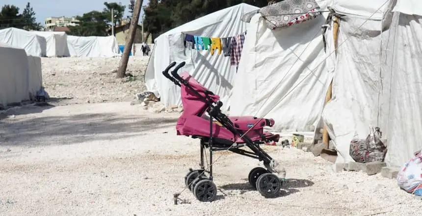 baby stroller outside tents for displaced families in Turkey