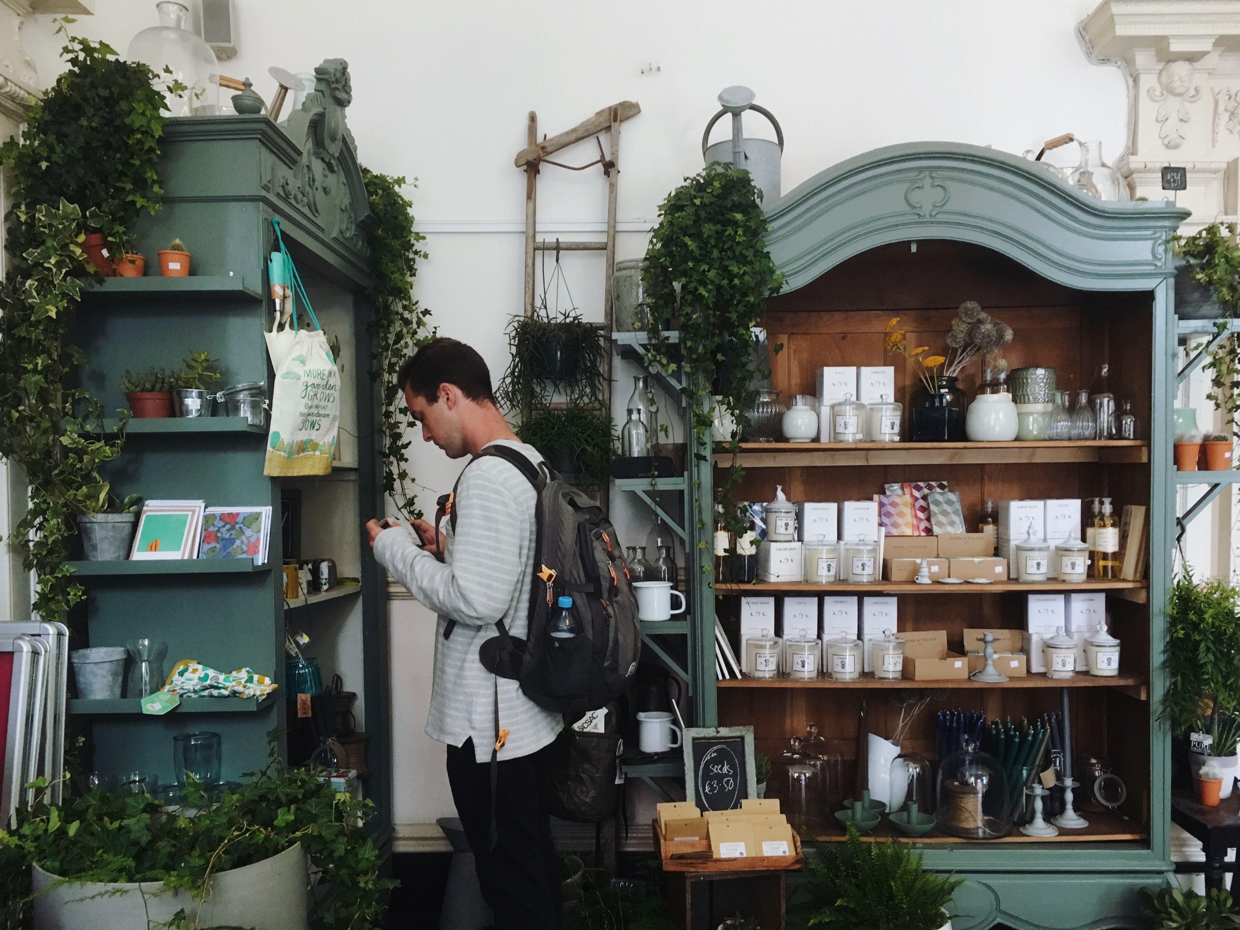 Man with a backpack shopping in a garden store