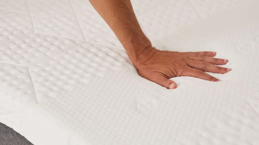 A hand on Emma Luxe Cooling mattress