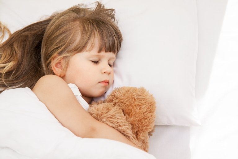 Sleeping girl with her teddy bear