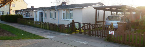 A single story prefab set back from a road