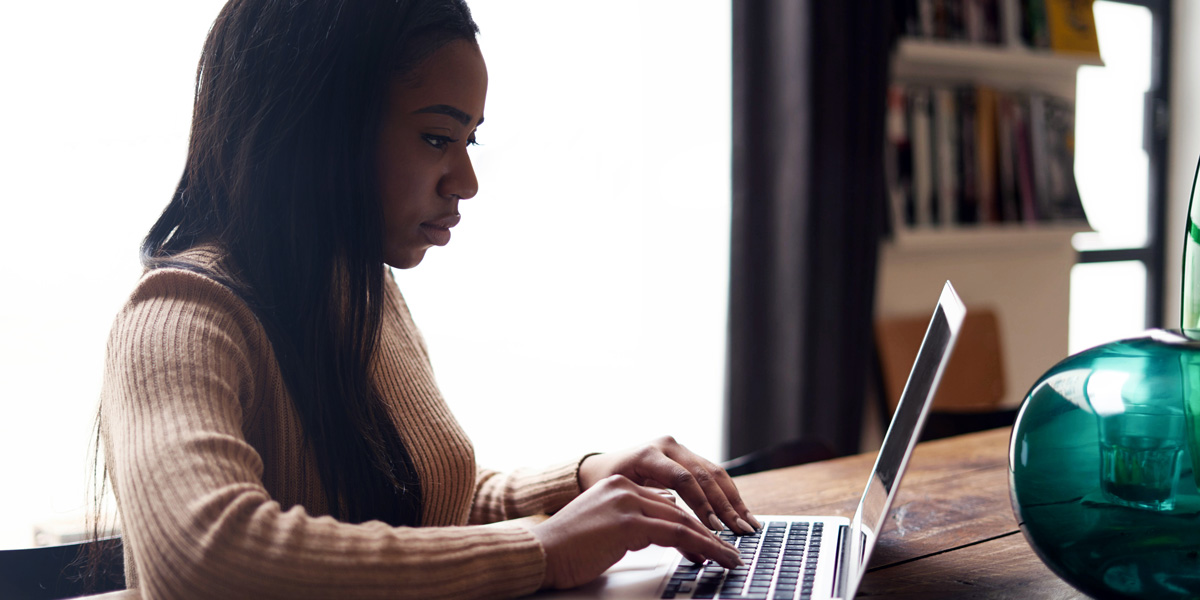 Day in the Life of a Lead UX Designer Lead UX designer sits at their desk, working on a laptop.