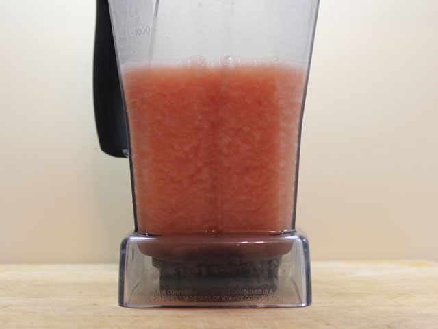 A Vitamix container filled with fresh watermelon cubes and light rum