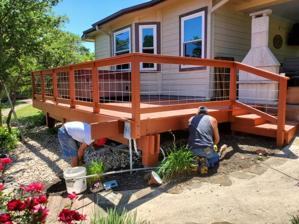 enlarged photo of before picture of a brown home being painted dark grey