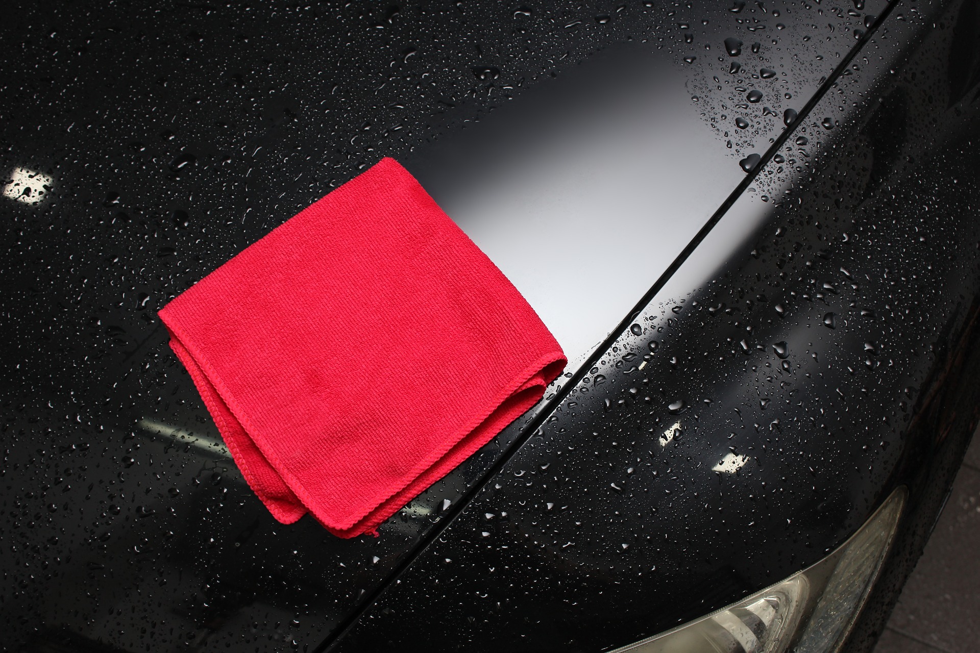 Red towel drying a wet black car Decatur Autowash good wash